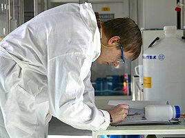 Researcher taking notes in a lab